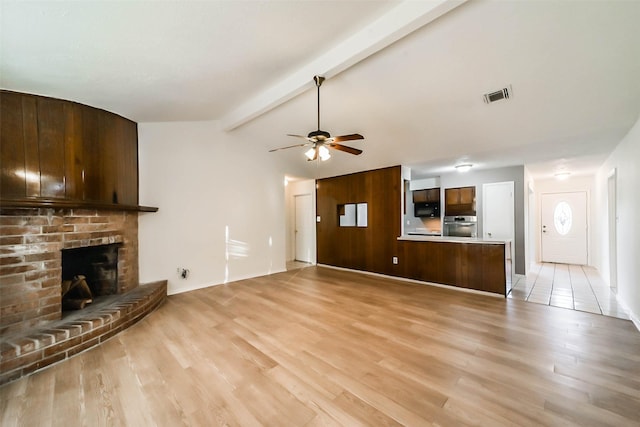 unfurnished living room with lofted ceiling with beams, ceiling fan, light wood-type flooring, and a fireplace