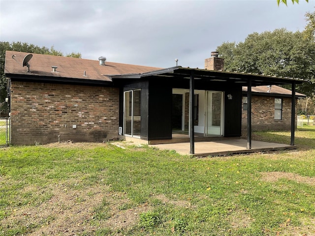 rear view of house featuring a yard and a patio