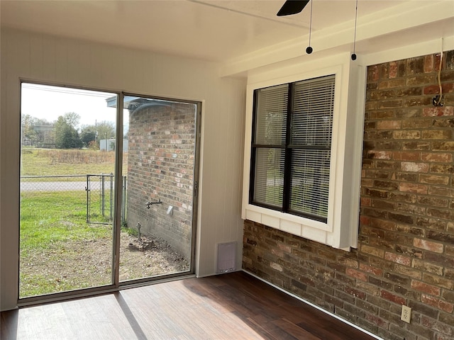 unfurnished sunroom featuring a healthy amount of sunlight and ceiling fan