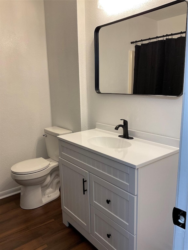 bathroom featuring a shower with curtain, vanity, hardwood / wood-style floors, and toilet