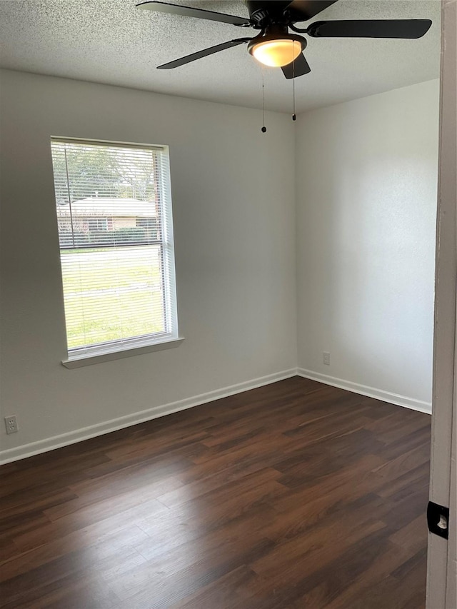 spare room featuring dark hardwood / wood-style flooring, ceiling fan, and a textured ceiling