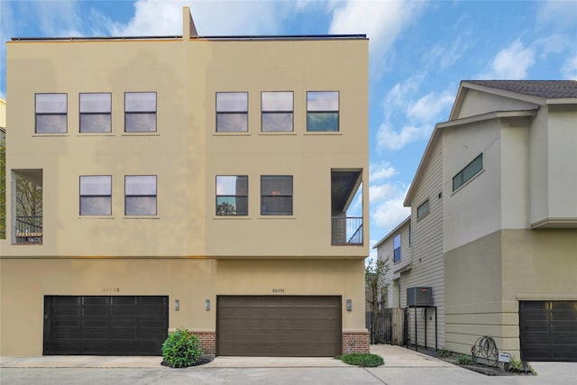 view of front of house featuring central AC, a balcony, and a garage