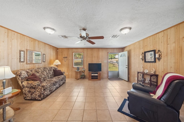 tiled living room featuring a textured ceiling, a wealth of natural light, and ceiling fan