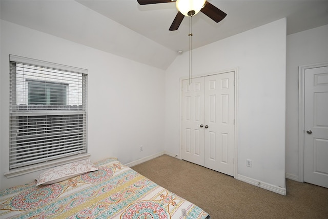 bedroom with a closet, vaulted ceiling, ceiling fan, and light colored carpet