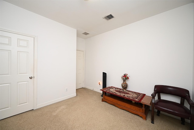 sitting room featuring light colored carpet