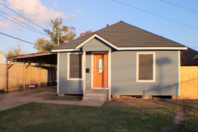 bungalow-style home featuring a carport and a lawn