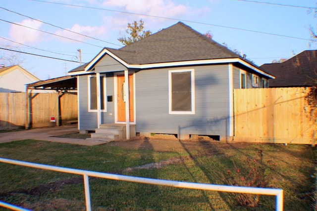 bungalow featuring a carport and a front lawn