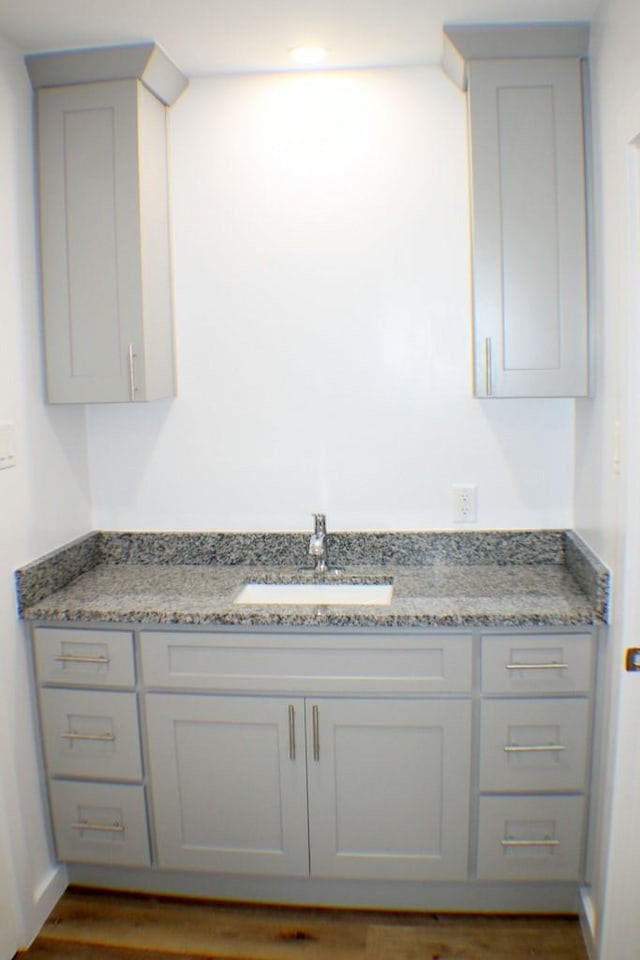 interior space featuring light stone countertops, dark wood-type flooring, and sink