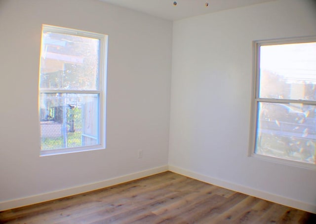 spare room featuring hardwood / wood-style floors and a healthy amount of sunlight