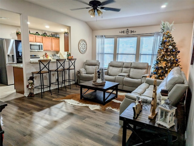 living room featuring ceiling fan, dark hardwood / wood-style flooring, and vaulted ceiling