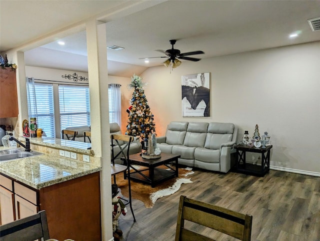 living room featuring dark hardwood / wood-style flooring, ceiling fan, sink, and vaulted ceiling