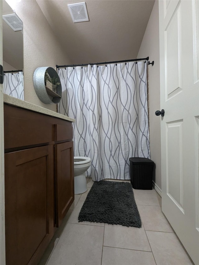 bathroom featuring toilet, vanity, and tile patterned floors