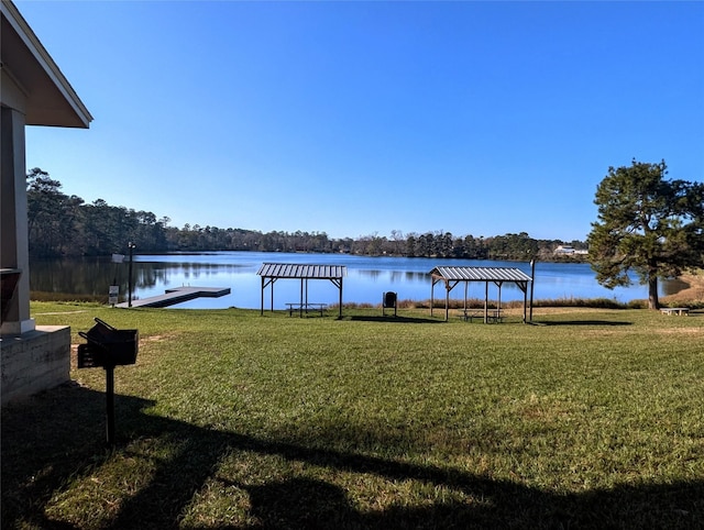 dock area with a gazebo, a water view, and a yard