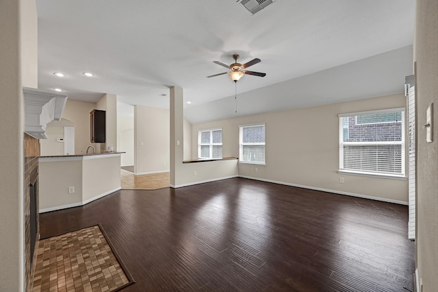 unfurnished living room featuring a wealth of natural light, hardwood / wood-style floors, ceiling fan, and lofted ceiling