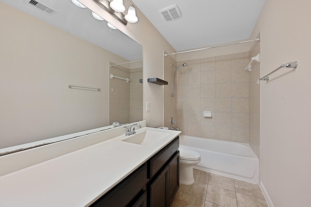 full bathroom with tile patterned flooring, vanity, tiled shower / bath combo, and toilet