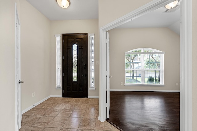 tiled foyer entrance featuring lofted ceiling