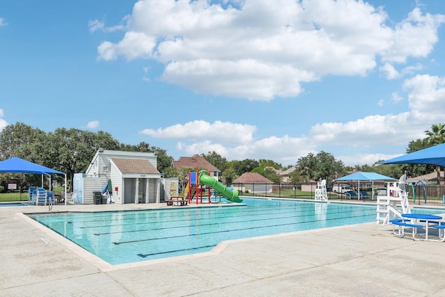 view of pool with an outbuilding, a patio, and a water slide