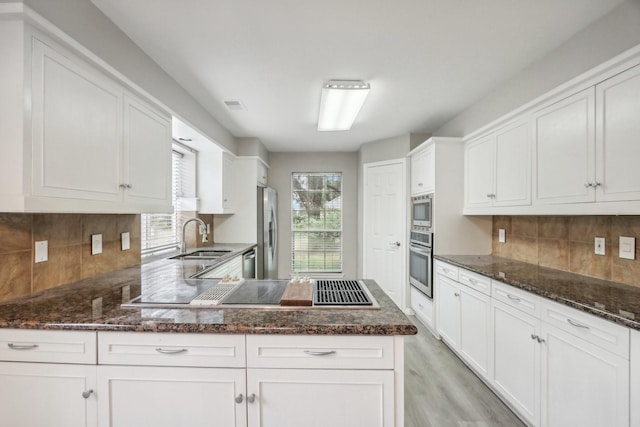 kitchen with white cabinets, sink, appliances with stainless steel finishes, and tasteful backsplash