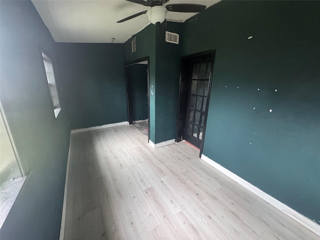 empty room with ceiling fan and light hardwood / wood-style flooring