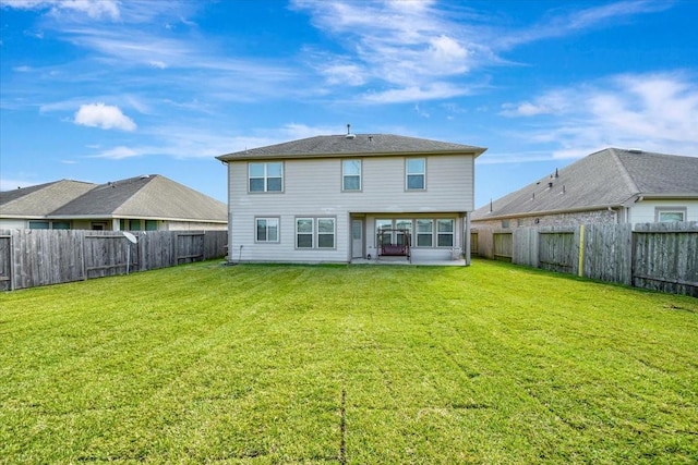 rear view of house featuring a lawn and a patio