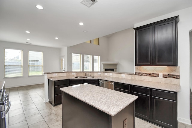 kitchen with backsplash, a kitchen island, plenty of natural light, and sink