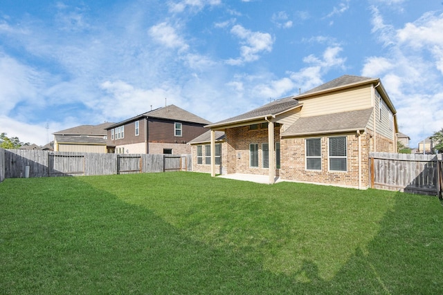 rear view of house with a patio area and a lawn