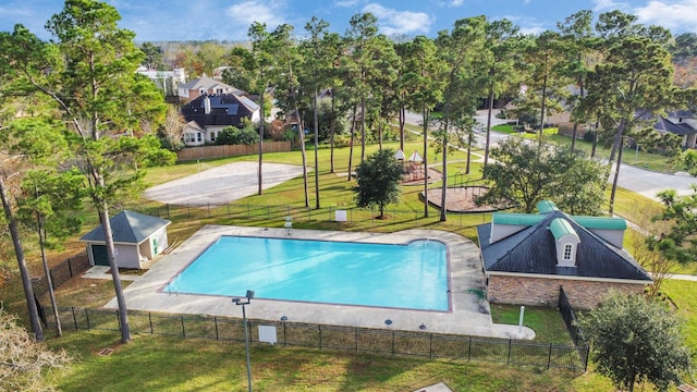 view of swimming pool with a lawn and an outbuilding