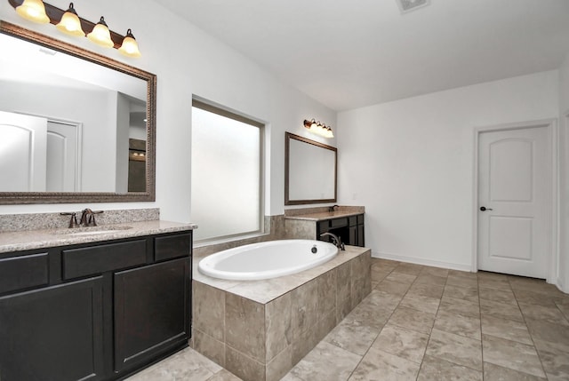 bathroom with tiled bath and vanity