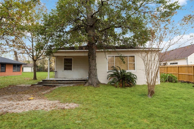 rear view of property featuring a yard