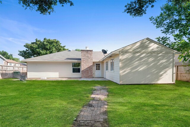 rear view of house featuring a lawn