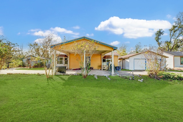 rear view of property with a yard, an outdoor structure, and a carport