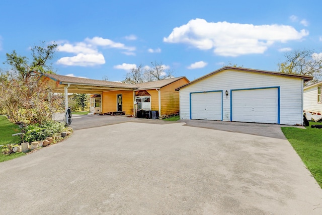 ranch-style home featuring a garage, a carport, and an outdoor structure