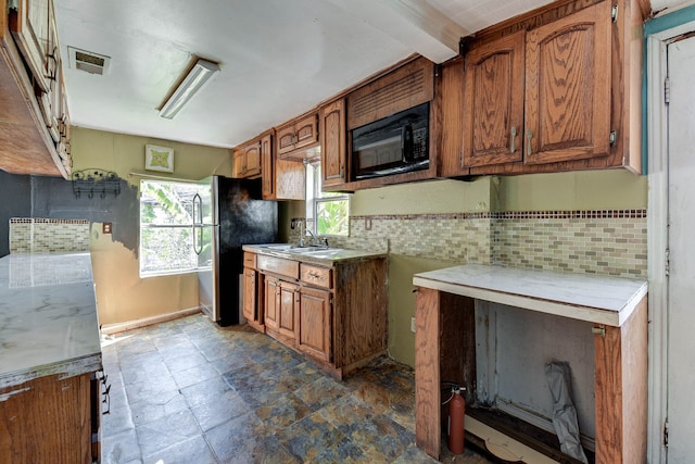 kitchen with sink, stainless steel refrigerator, and tasteful backsplash