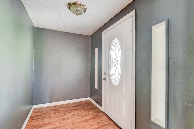 entryway with a textured ceiling and light wood-type flooring