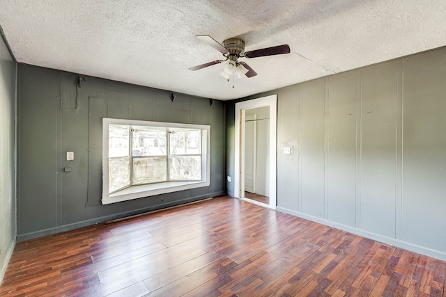 unfurnished bedroom with ceiling fan, dark wood-type flooring, and a textured ceiling