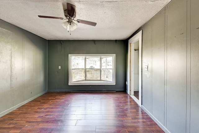 unfurnished bedroom with ceiling fan, dark hardwood / wood-style flooring, and a textured ceiling