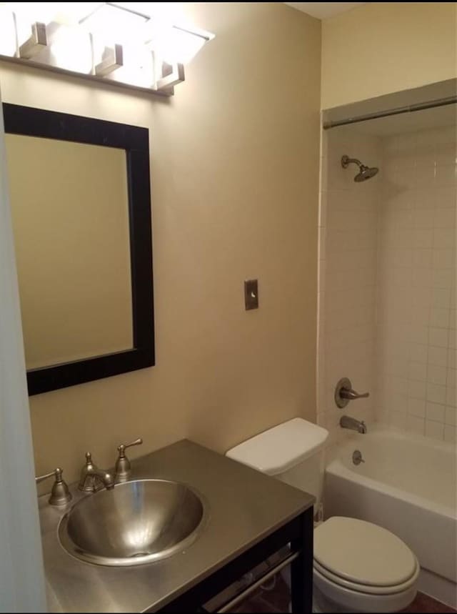 full bathroom with vanity, tiled shower / bath combo, and toilet