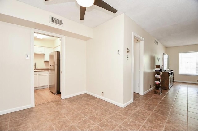 unfurnished room with ceiling fan and sink