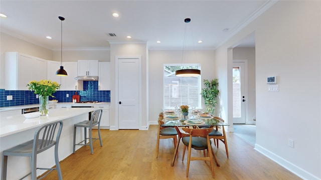 dining room featuring light hardwood / wood-style flooring and ornamental molding