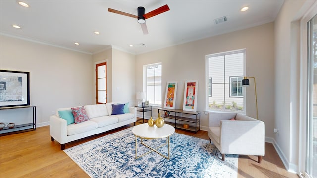 living room featuring ceiling fan, ornamental molding, and light hardwood / wood-style flooring