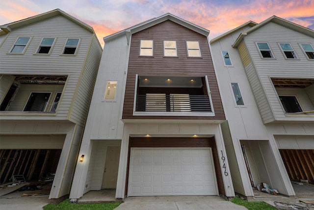 view of front of property featuring a balcony, an attached garage, board and batten siding, and driveway