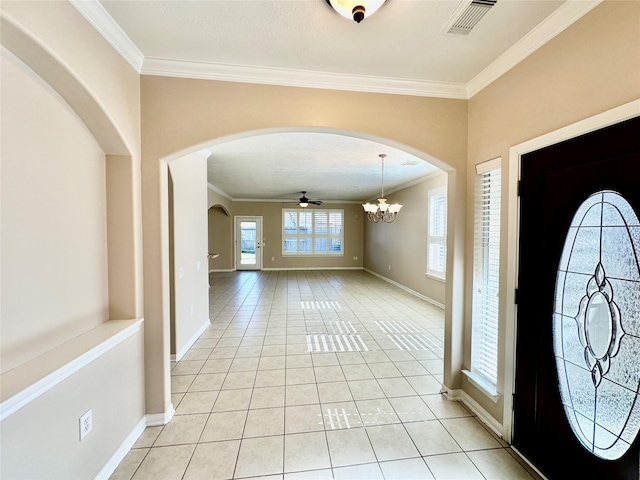 entryway featuring ceiling fan with notable chandelier, light tile patterned floors, and crown molding