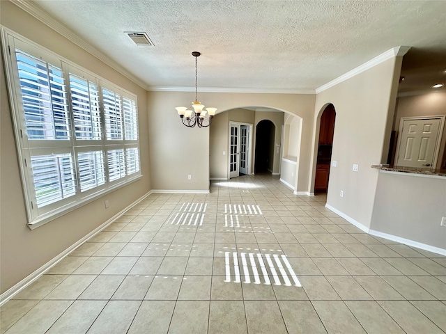 tiled spare room featuring a chandelier, a textured ceiling, and crown molding