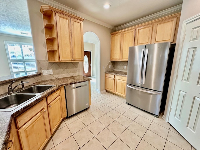 kitchen with tasteful backsplash, stainless steel appliances, crown molding, sink, and light tile patterned floors