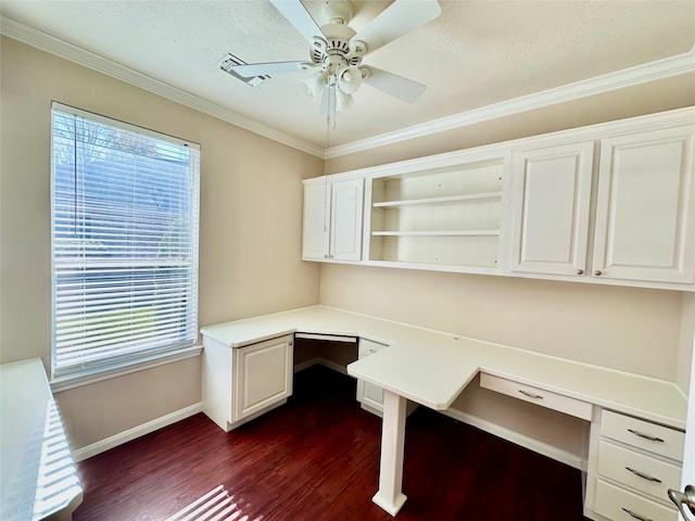 unfurnished office featuring ceiling fan, dark wood-type flooring, built in desk, and ornamental molding