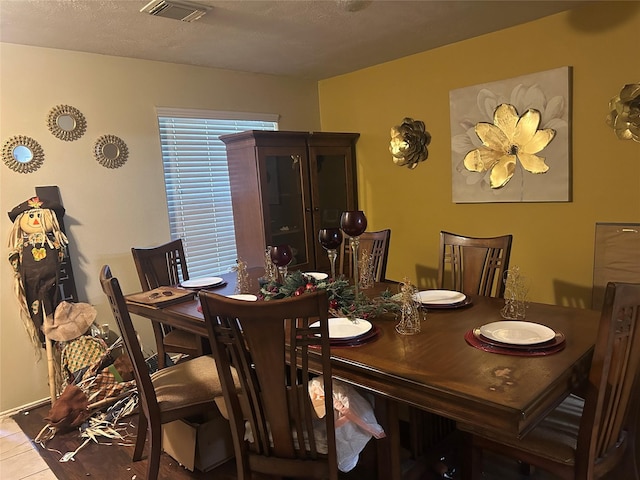 dining room featuring light tile patterned flooring and a textured ceiling