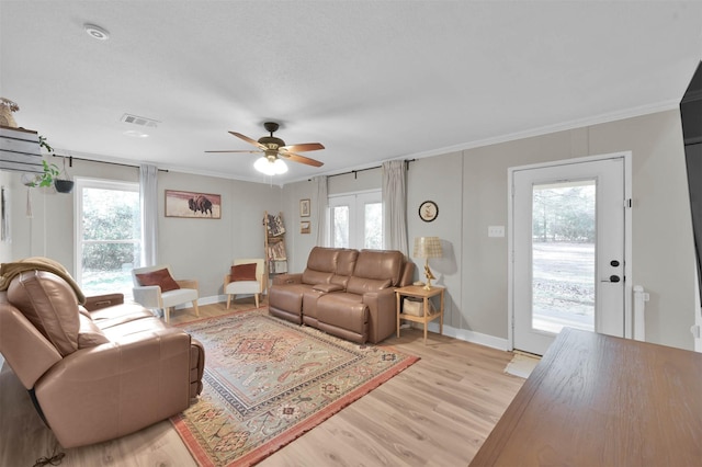 living room with ceiling fan, ornamental molding, and light wood-type flooring