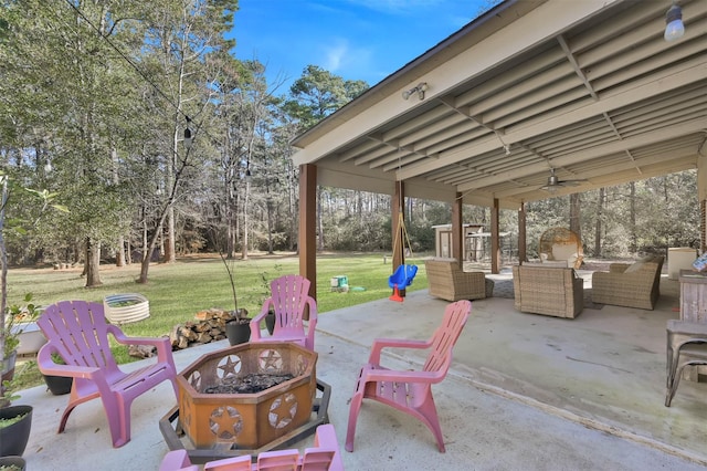 view of patio featuring ceiling fan and an outdoor living space with a fire pit