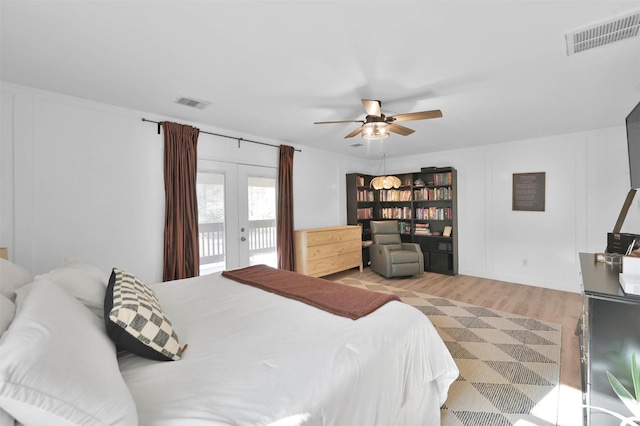 bedroom featuring access to exterior, french doors, light hardwood / wood-style floors, and ceiling fan