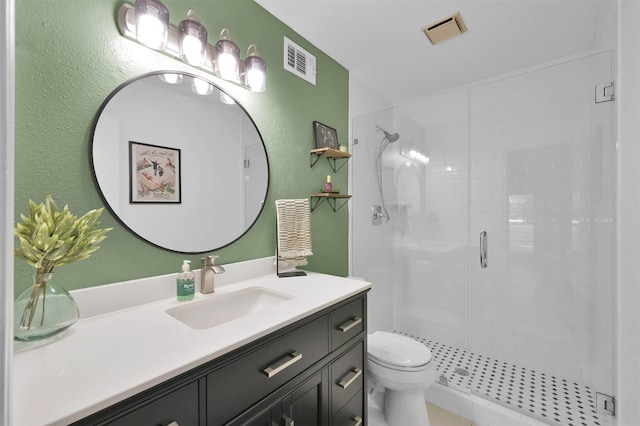 bathroom featuring vanity, toilet, and a shower with door